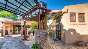 A courtyard with stone flooring, a pergola, potted plants, and a stone pillar. - Casa Vista- House With A View. A Unique Spanish Style Home (Ilkley)