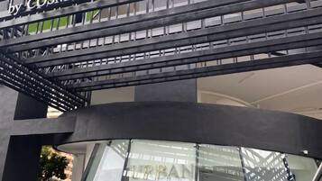 A modern building with a curved glass facade and a sign for 'Urban Suites.'