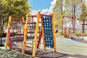 Une aire de jeux avec des structures d’escalade et des balançoires.