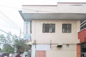 Un edificio con un letrero que indica 'Pension Inn' y un número de contacto.