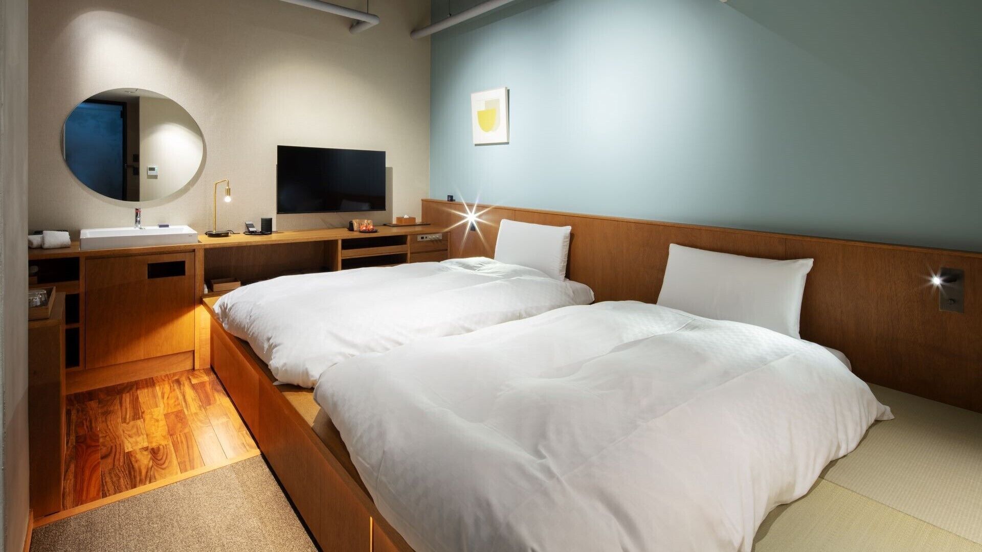 A hotel room with a wooden bed, a TV, a mirror, and a desk.