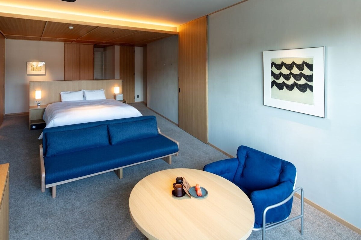Une chambre d’hôtel avec un lit, un canapé, une table ronde et une chaise.