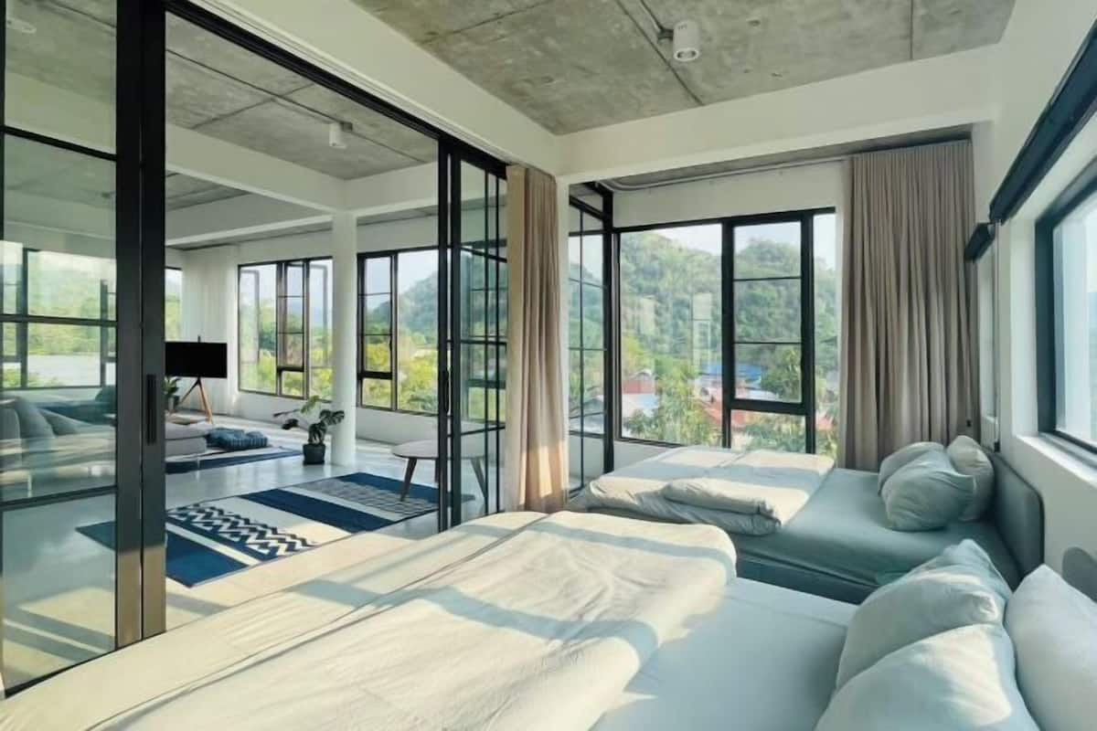 Une chambre d’hôtel moderne avec un grand lit, un canapé et une télévision.