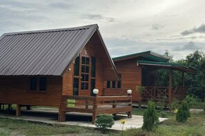Une cabane en bois avec un toit en pente et une véranda.