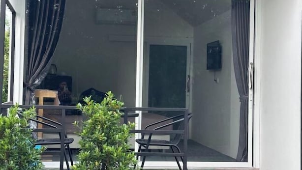 A room with a sliding glass door, a small table, and a chair. - INK-PHA GARDENVIEW RESORT (Noen Maprang)