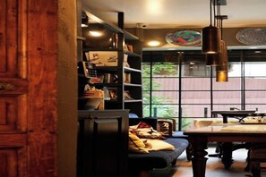 A cozy room with a wooden door, a bookshelf, a dining table, and a large window. - FAIK PASHA HOTELS (Istanbul)