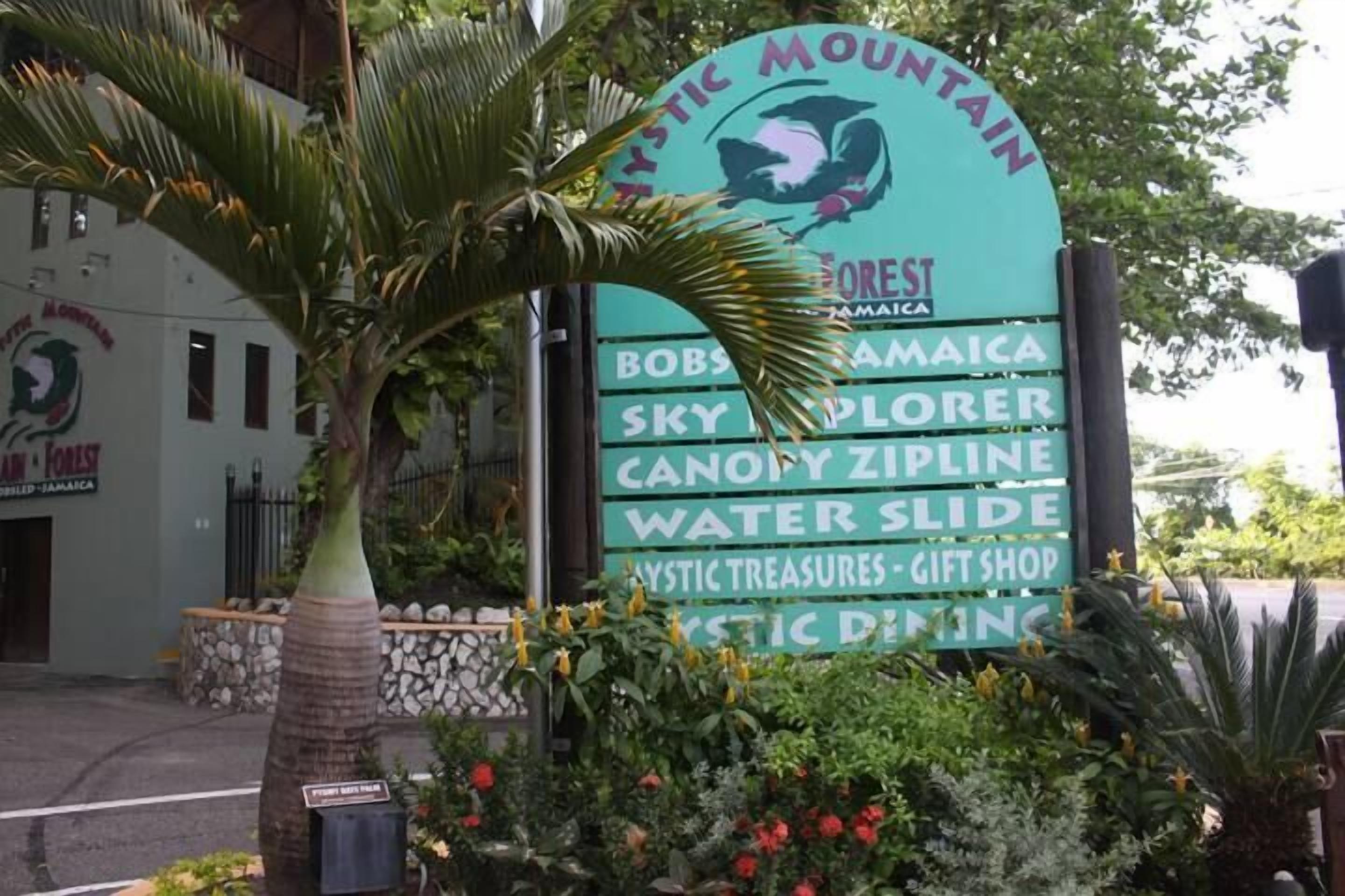 A sign for 'Mystic Mountain' with amenities like 'Bob's Jamaica', 'Sky Explorer', 'Canopy Zipline', 'Water Slide', and 'Mystic Treasures - Gift Shop'.