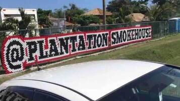 Una señal con el texto 'PLANTATION SMOKEHOUSE' en una fuente decorativa.