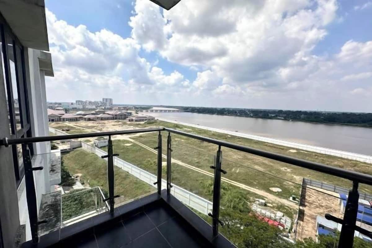 Ein Balkon mit Blick auf einen Fluss und entfernte Gebäude.