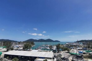 A marina with boats docked, a clear sky, and distant mountains. - Rustic One Bedroom Unit for 4Pax by Jomy Management (Manjung)