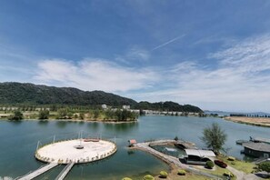 A circular water body with a dock, surrounded by greenery and buildings. - Rustic One Bedroom Unit for 4Pax by Jomy Management (Manjung)