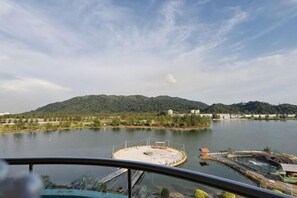 A lake with a dock, a circular structure, and a distant hill. - Rustic One Bedroom Unit for 4Pax by Jomy Management (Manjung)