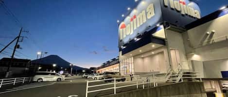 A building with a prominent sign reading 'Tajima' and a parking lot with a 'STOP' marking.