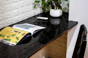 A kitchen counter with a magazine, a white appliance, and a potted plant. - Lotus Laverne Hotel (Ho Chi Minh City)