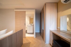 Un baño moderno con un tocador de madera, un espejo y una zona de ducha.