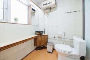 A modern bathroom with a toilet, sink, and window. - VietHOME - 22 Pho Hue - Apartment 702 (Hanoi)