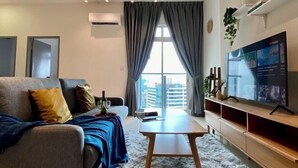 A modern living room with a sofa, a coffee table, a TV, and a large window with curtains. - TR Residence Titiwangsa By Iconique (Kuala Lumpur)