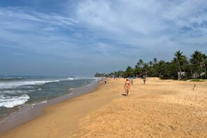 A beach with a sandy shore, palm trees, and ocean waves. - Pearl Island Beach Hotel (Hikkaduwa)