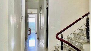 A hallway with a staircase leading to a landing. - Fuji sapa central hostel (TT. Sa Pa)