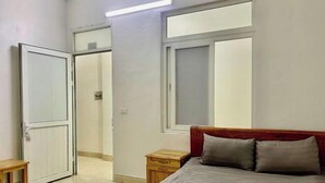 A bedroom with a bed, bedside tables, a window, and a door. - Fuji sapa central hostel (TT. Sa Pa)