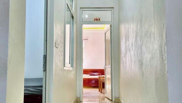 A hallway leading to a room with a bed and a table. - Fuji sapa central hostel (TT. Sa Pa)