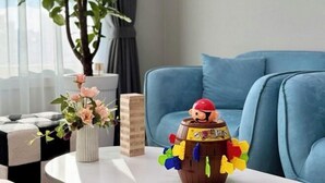 A room with a blue sofa, a small table with a decorative item, and a potted plant. - EunhasuD&M Residence Hotel (Daejeon)