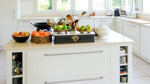 A modern kitchen with a central island, white cabinetry, and a large window providing natural light. - Relaxation between vineyards and ocean, family house with swimming pool,Bordeaux (Plassac)