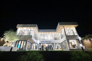 A modern villa with a prominent entrance, large windows, and a sign reading 'PAMTA POOL VILLA.' - Panita Poolvilla (Photharam)