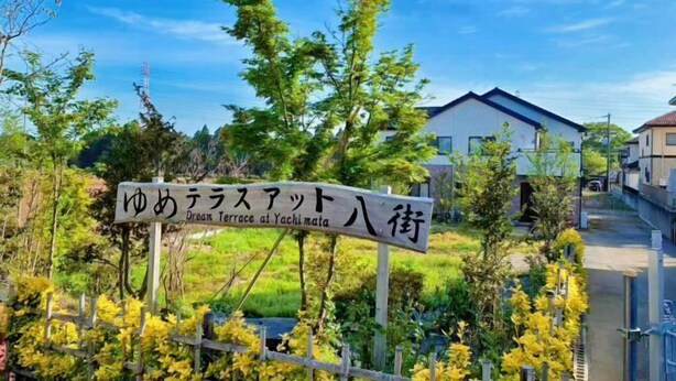 A sign for 'Dreams Terrace at Yachimata' with a view of a residential area and greenery. - Yume Terrace at Yachimata (Yachimata)