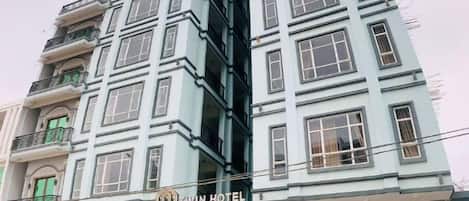 Un hotel de varios pisos con un letrero llamativo que dice 'Twin Hotel'.