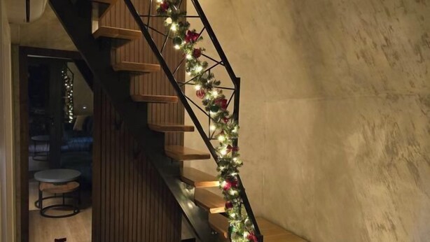 A staircase with wooden steps and a metal railing, decorated with string lights and red flowers. - ZEN Luxury Houses & Spa Zlatibor (Municipality of Cajetina)