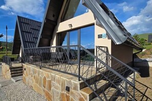 Un edificio con base de piedra, barandilla de metal y un letrero que indica el número de habitación 2.