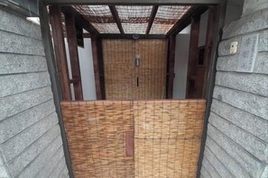 A traditional Japanese-style entrance with a wooden door and a bamboo screen.