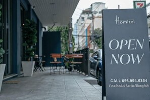Ein Hotel-Schild mit der Aufschrift 'OPEN NOW' und Kontaktinformationen.