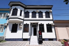 A two-story building with a black and white facade, a central entrance, and a signboard. - zhongtian (Tashkent)