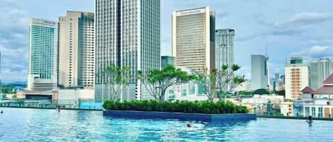 A swimming pool with a city skyline in the background.