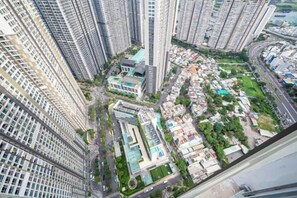 A high-rise building with multiple floors, a central courtyard, and surrounding residential areas. - VINHOMES APARTMENT LUXURY IN HCMC (Ho Chi Minh City)