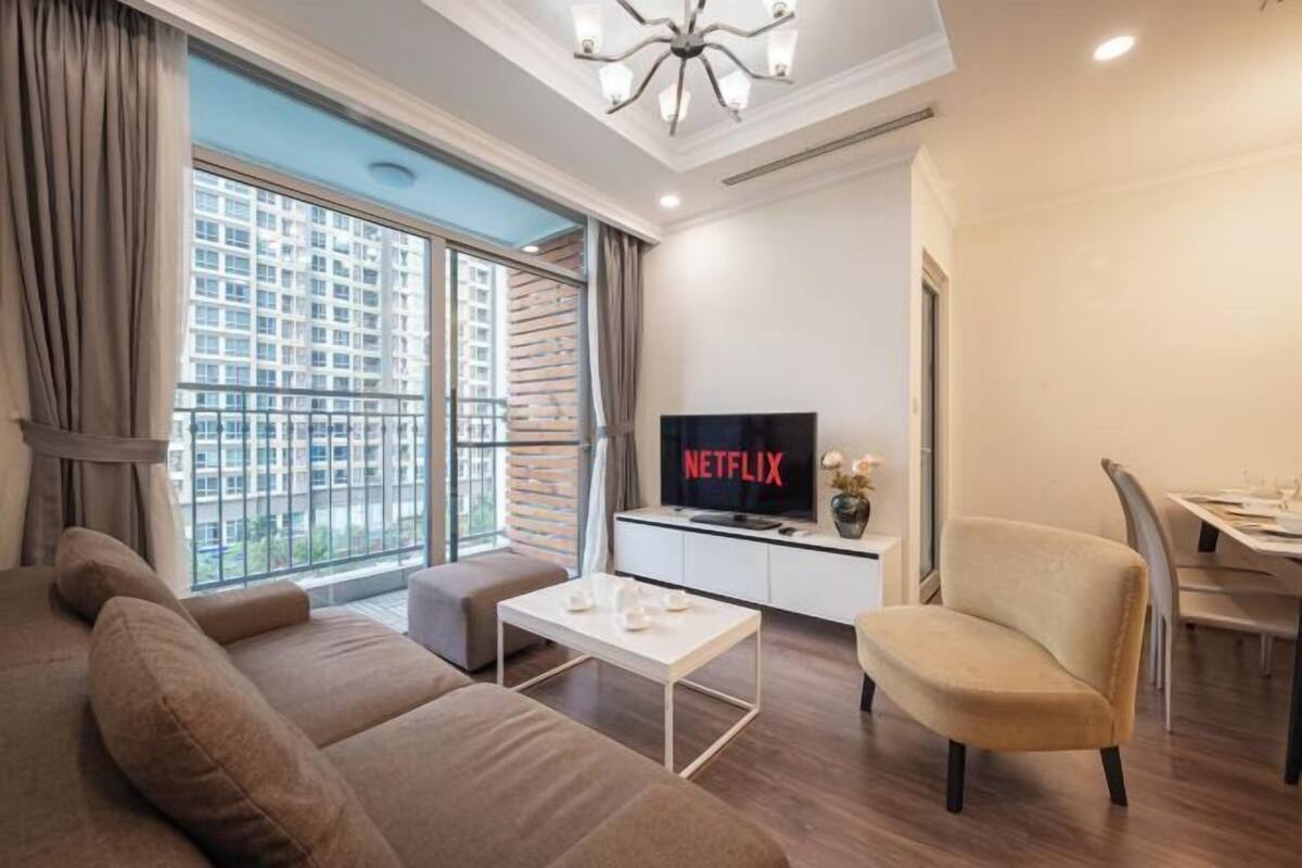 A modern living room with a sofa, a coffee table, and a TV displaying 'NETFLIX'.