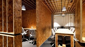 A conference room with a wooden table and chairs, a ceiling with exposed beams, and pendant lighting. - Student Only AXO Camden (London)
