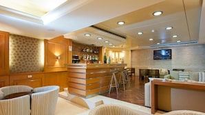 A bar area with a counter, stools, and a seating area with couches and chairs. - Hotel Cavalier (Beirut)