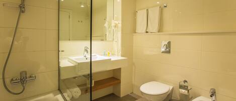 A modern bathroom with a glass-enclosed shower, a sink, a toilet, and a bidet.