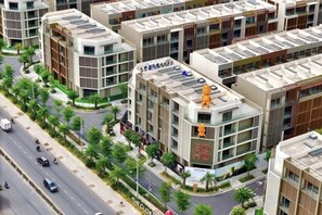 A multi-story building with a modern architectural design, featuring a mix of glass and concrete facades, and a prominent corner entrance. - KN Holiday Home in Global City (Ho Chi Minh City)