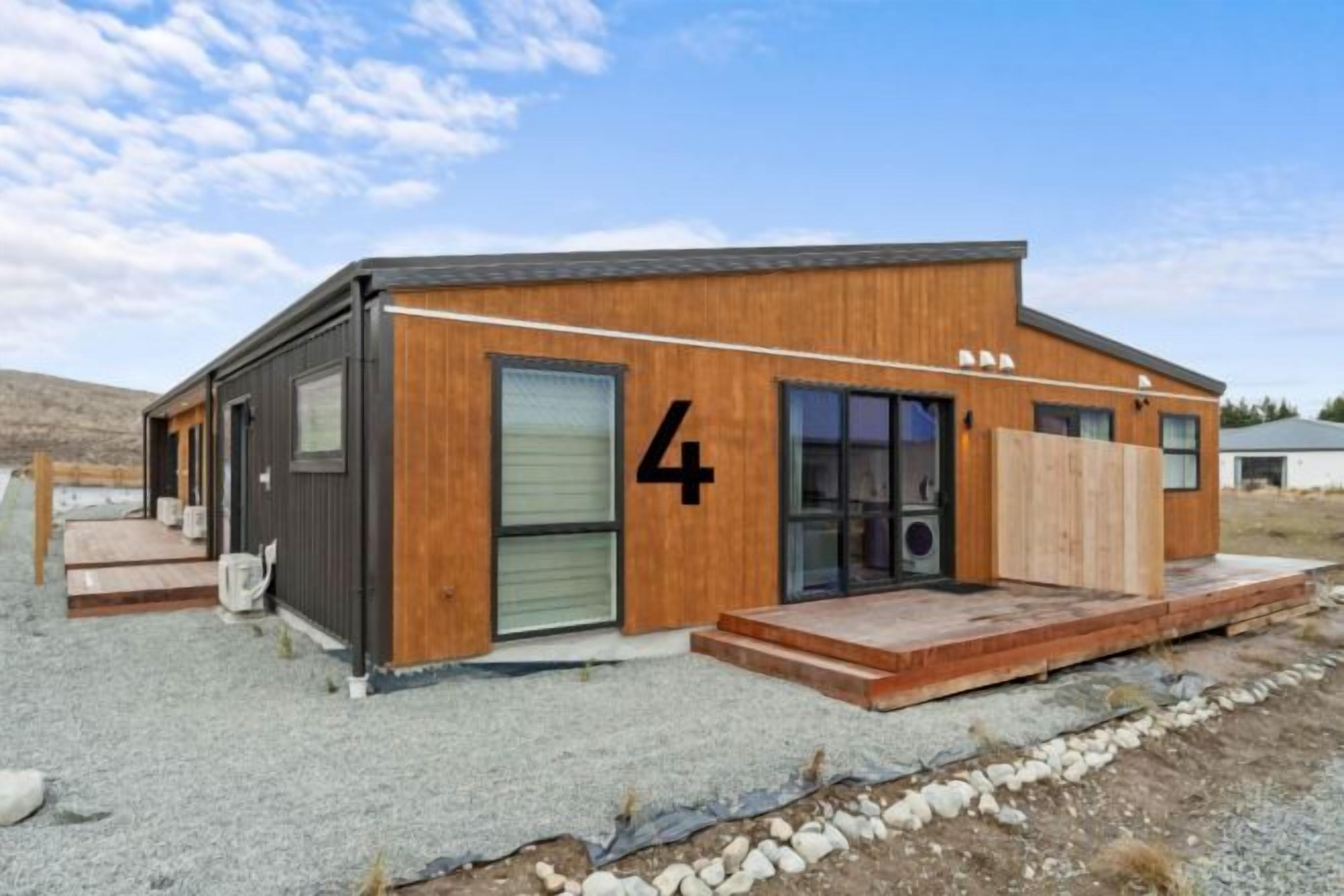 Un bâtiment moderne avec le chiffre « 4 » peint sur le côté, une porte en bois et un petit porche.