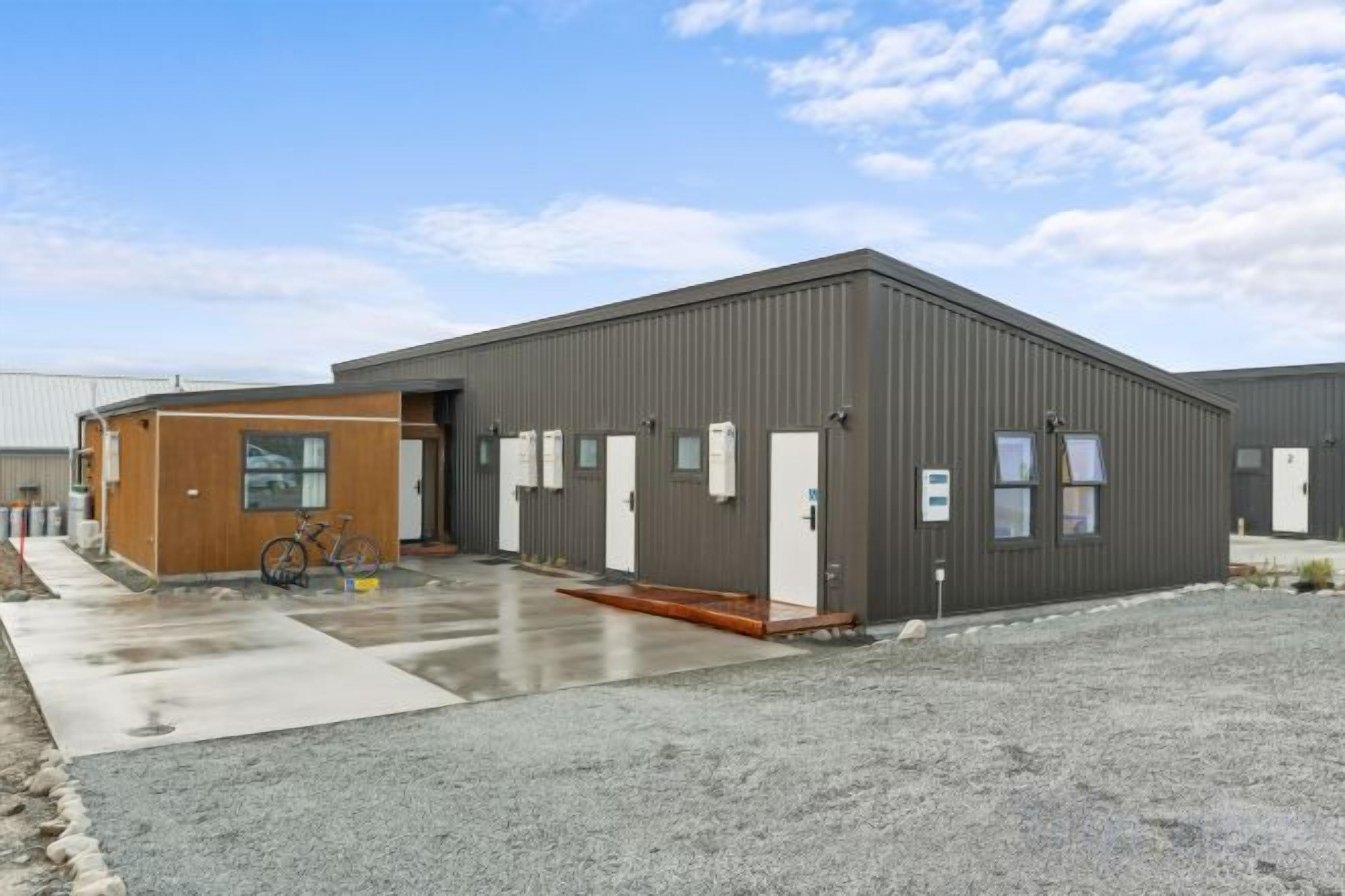 A modern building with a large entrance, a smaller attached structure, and a bicycle parked outside.