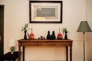 A wooden console table with decorative items and a framed picture above it. - Barn Laos Luangprabang Heritage (Luang Prabang)