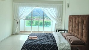 Um quarto com uma cama, uma mesa de cabeceira e uma janela com cortinas.