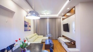 Ein modernes Wohnzimmer mit Esstisch, Sofa und Fernseher.