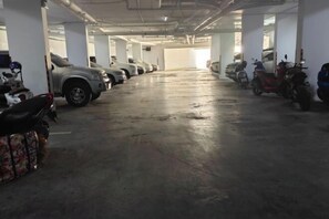 A multi-level parking garage with several cars and scooters parked. - City Garden Olympus Condominium 1room (Pattaya)