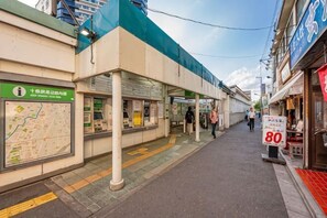 A train station platform with a map, information boards, and a sign indicating a sale.