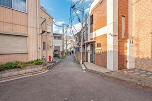 A narrow urban street with buildings on both sides. - W.Hostel (Tokyo)